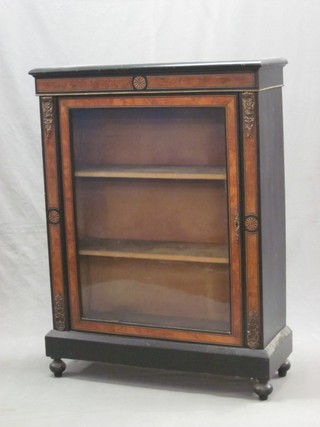 A Victorian ebonised and walnut pier cabinet the interior fitted shelves enclosed by glazed panelled doors with gilt metal mounts to the sides, raised on bun feet 31"