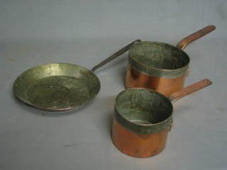 A copper frying pan with iron handle and 2 copper saucepans