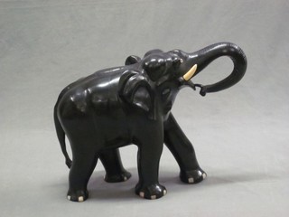 An ebony and ivory figure of a walking elephant 21"