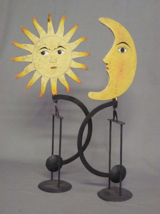 2 painted iron ornaments in the form of stylised sun and crescent moon with moving eyes