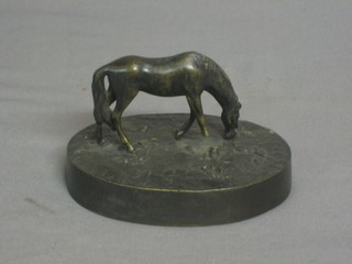 A 19th Century bronze paperweight in the form of a standing grazing horse, raised on an oval naturalistic base 4" (f)