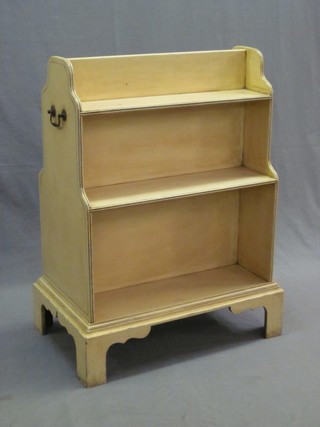 A Regency style white painted double sided bookcase, raised on bracket feet with brass drop handles to the side 23"