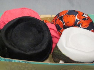 A lady's grey felt hat with blue banding, a black felt hat, a pink hat with tassels and a black and red silk print hat
