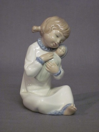 A Nao figure of a seated girl cradling a doll 6" (unboxed)