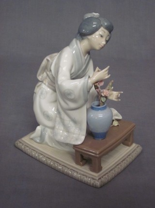 A Lladro figure of a seated Oriental lady arranging flowers (hand f) base impressed T220