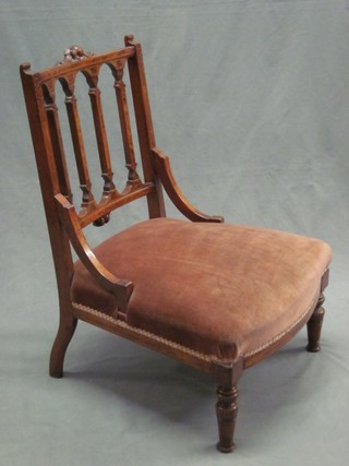 A Victorian walnut stick and rail back nursing chair with upholstered seat raised on turned supports