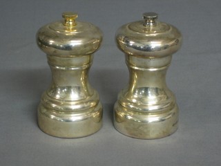 A pair of modern silver salt and pepper mills of waisted form