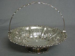A George III circular embossed silver cake basket with swing handled, raised on a spreading foot, marks rubbed, 25 ozs