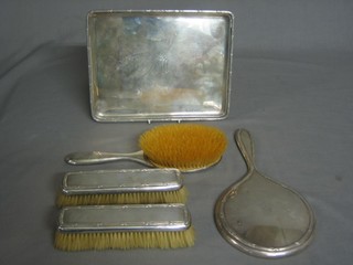 A handsome 5 piece silver backed dressing table set comprising  rectangular tray London 1919 12 ozs, a pair of clothes brushes, hair brush and hand mirror, monogrammed
