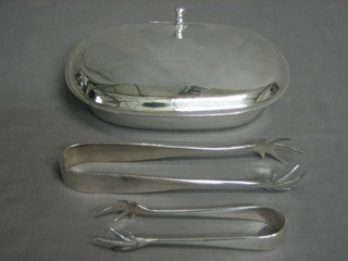 An oval silver plated dish with armorial decoration and 2 pairs of silver plated ice tongs