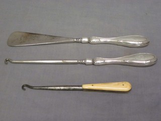 A silver handled button hook, shoe horn and 1 other button hook