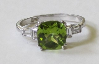 A lady's 18ct white gold dress ring set a square cut peridot and having 4 baguette cut diamonds to the shoulders