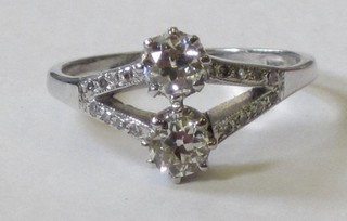An 18ct white gold dress ring set 2 diamonds, supported by diamonds, approx 0.66ct