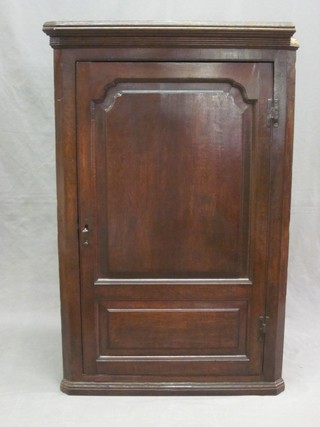 A Georgian Country oak corner cabinet with moulded cornice, fitted shelves with 2 drawers to the base enclosed by a panelled door 28" 