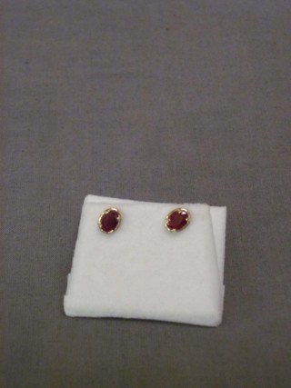 A pair of 9ct gold ear studs set oval cut rubies