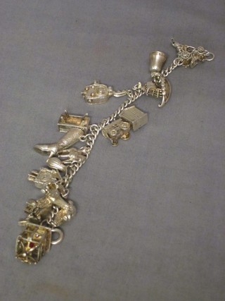 A silver curb link charm bracelet hung numerous charms, 2 ozs