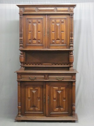 A French oak cabinet on cabinet, the upper section with moulded cornice, the interior fitted shelves enclosed by panelled doors with niche, the base fitted 2 long drawers above a double cupboard with column decoration to the side 45"