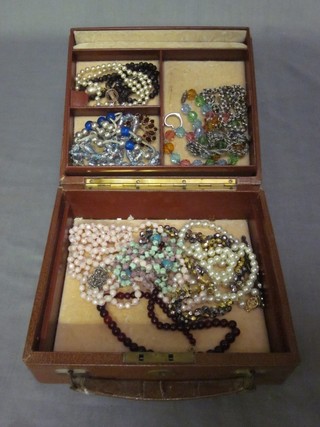 A leather jewellery case containing a collection of costume jewellery