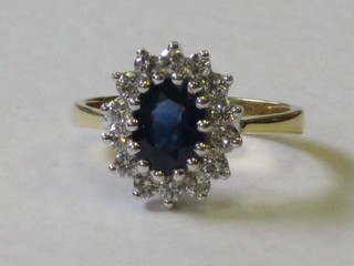 A lady's 18ct yellow and white gold dress ring set an oval sapphire surrounded by diamonds