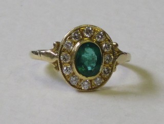 A lady's 18ct gold dress ring set an oval cut emerald surrounded by 12 diamonds