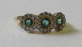 An 18ct yellow gold dress ring set 3 emeralds supported by diamonds
