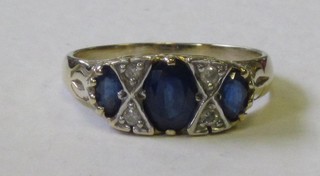 A lady's 18ct yellow gold dress ring set 3 oval cut sapphires supported by 4 diamonds