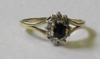 A lady's 9ct gold dress ring set a small sapphire surrounded by diamonds