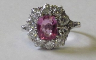 An 18ct white gold dress ring set an oval cut pink sapphire surrounded by diamonds, approx 1.30/2ct