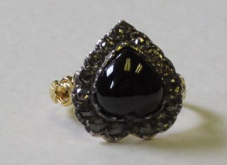 A lady's 18ct gold dress ring set a cabouchon heart shaped garnet surrounded by diamonds