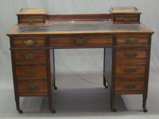 An Edwardian walnut writing table the top fitted 2 drawers with pierced brass gallery and inset writing surface, above 1 long and 8 short drawers with reeded decoration to the sides, 48"