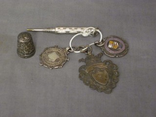 3 silver watch chain medallions, a silver thimble, a propelling pencil