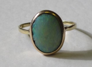 A gold dress ring set an oval cut opal