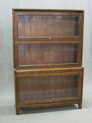 An oak 3 tier Globe Wernicke style bookcase enclosed by lead glazed panelled doors 34 1/2"