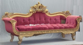 A handsome French style carved gilt wood sofa surmounted by an eagle and upholstered in rose pink Dralon 93"