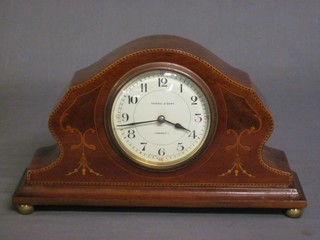 A 1930's bedroom timepiece with enamelled dial and Arabic numerals by Kendall & Dent contained in an inlaid mahogany case