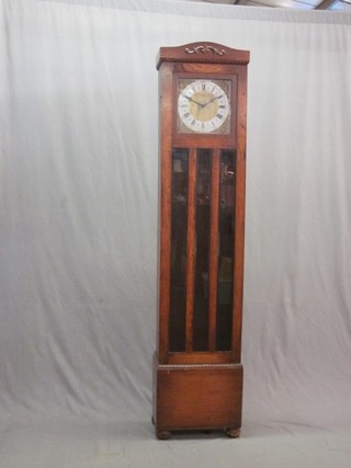 A 1930's 8 day chiming longcase clock with 10" square dial with silvered chapter ring and Roman numerals contained in an oak case, raised on bun feet 75"