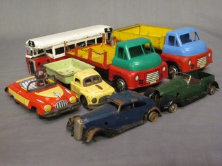 A tin plate model motor coach, 2 tin plate clock work drop sided trucks, 1 other truck and 3 model cars