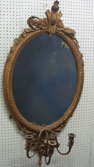 A 19th Century oval plate mirror contained in a gilt plaster frame with 3 candle sconces to the base 27"