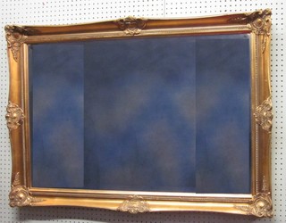 A rectangular bevelled plate wall mirror contained in a decorative gilt frame 42" x 29"