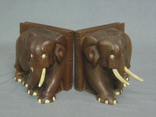A pair of carved Eastern wooden bookends in the form of elephants 5"