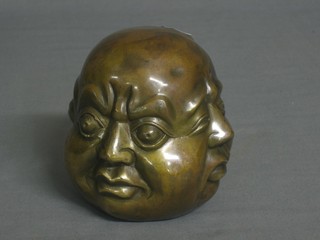 A bronzed ornament in the form of a Buddhas head