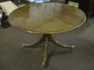 A Georgian style oval extending dining table raised on a pillar and tripod base 48"