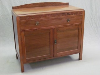 An Edwardian walnut wash stand with raised back, fitted a drawer above a double cupboard with blind fret work decoration 35"