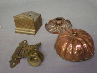 A pressed metal money box in the form of a bank 4", an embossed copper stub shaped candlestick 4" and a circular copper mould 5"