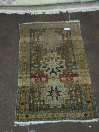 A tan ground Caucasian rug with 3 stylised medallions to the centre 81" x 44" (slight hole)