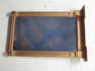 A rectangular plate mirror contained in a decorative gilt frame supported by 2 reeded columns 33"