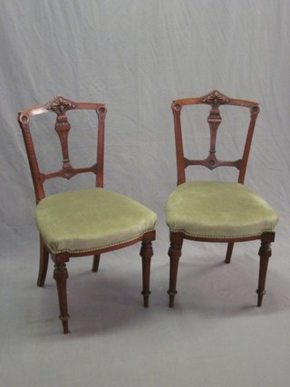 A pair of Victorian carved walnut slat and rail back dining chairs with upholstered seats, raised on turned and fluted supports