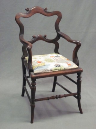 A childs Victorian rosewood carver chair with shaped mid rail and upholstered drop in seat, raised on turned supports