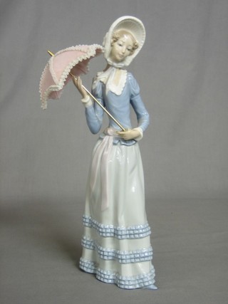 A Lladro figure of a standing lady holding a parasol 12" (parasol glued)