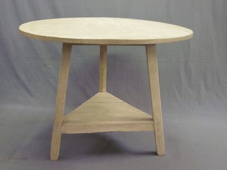 A circular white painted cricket table with undertier raised on square supports 38"